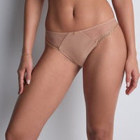 beige bikini bottom with gold accents on a neutral background