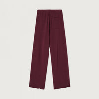 A pair of wide-leg knit pants in a deep burgundy color, featuring an elastic waistband and a single welt pocket on the back right leg, shown flat against a light off-white background.