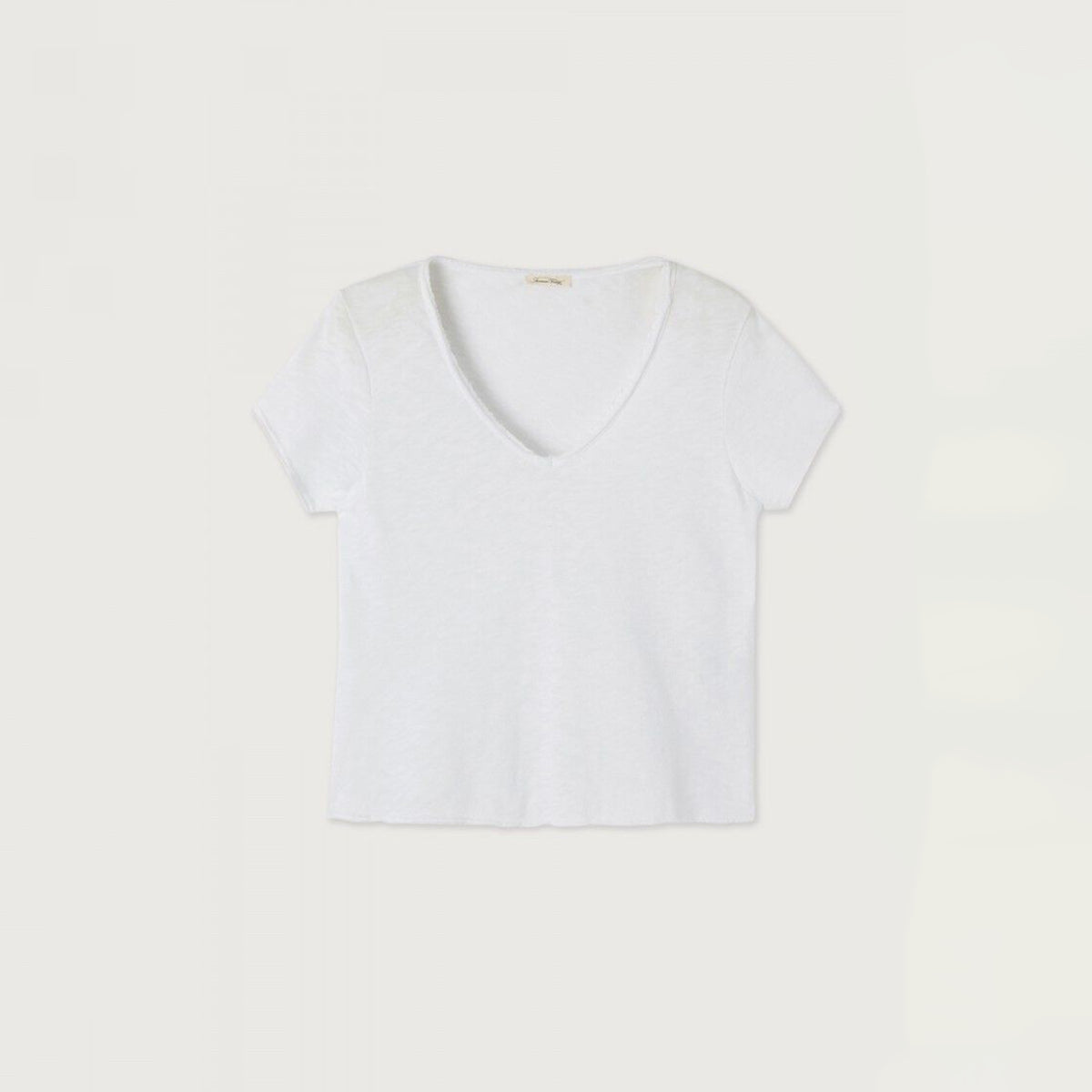 A white short-sleeve V-neck top laid flat against a light beige background.
