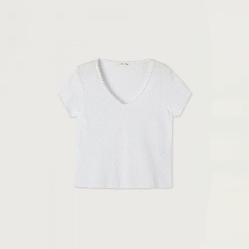 A white short-sleeve V-neck top laid flat against a light beige background.