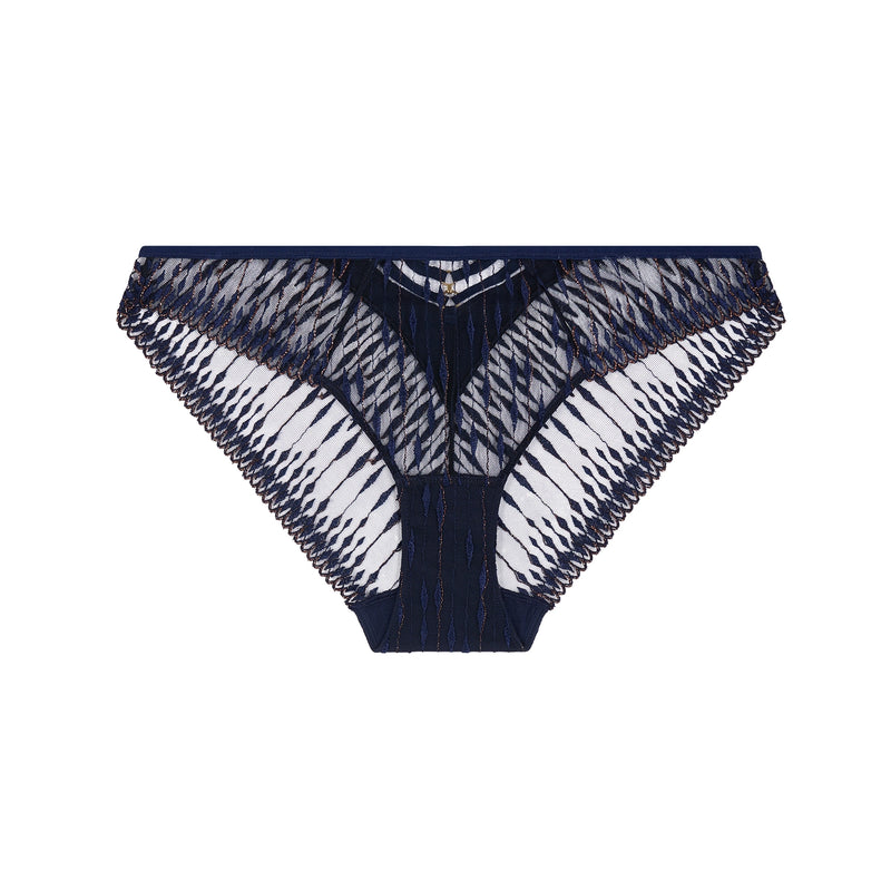 Cut out of a navy blue brief with gold-tone detail and sheer patterned mesh, photographed against a plain light beige studio background.