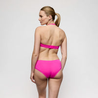 woman wearing a pink lingerie against a plain background