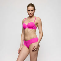 woman wearing a bright pink bikini against a plain background