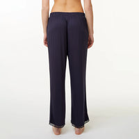 A model shown from the back wearing dark navy wide-leg lounge pants with a lace trim at the hem, against a plain white studio background.