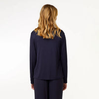 A woman with blonde hair is shown from the back wearing a dark navy blue long-sleeve top and matching pants against a plain white background.