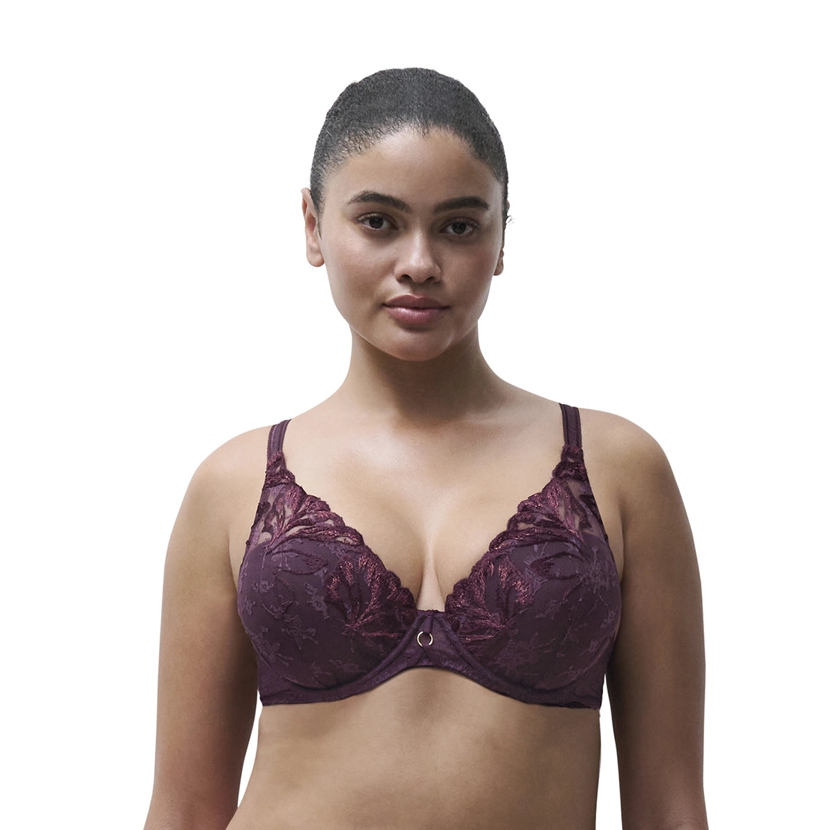 A woman modeling a dark plum lace bra against a plain white background.