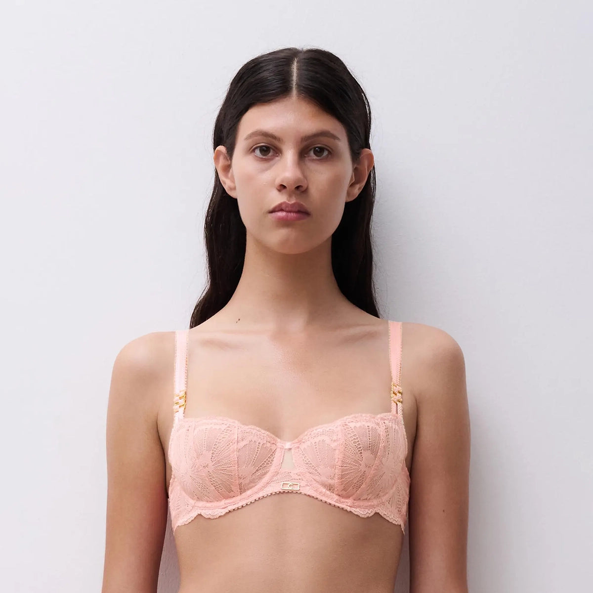 woman wearing a pink bra against a white background