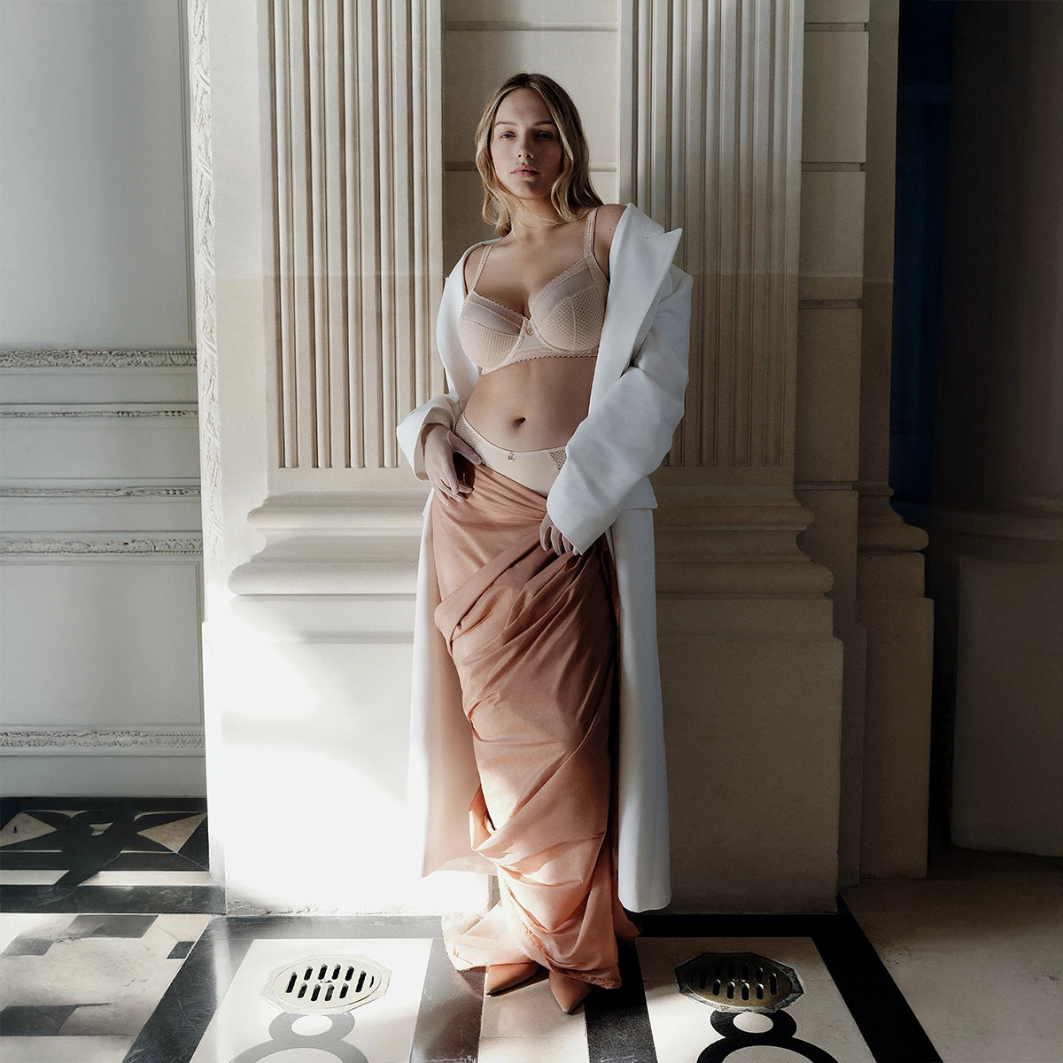 woman in a stylish outfit standing in an elegant interior setting