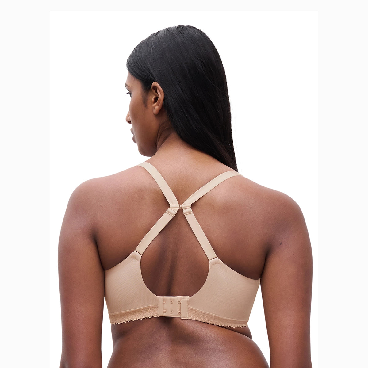 woman wearing a beige bralette on a white background