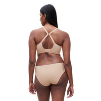 woman wearing a beige lingerie set on a white background