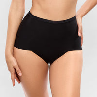 person wearing black high-waisted underwear on a plain background