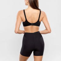 person wearing a black sports bra and shorts on a light grey background