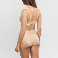 A woman shown from the back wearing a beige high-waisted shapewear brief and matching bra, photographed against a light gray studio background.