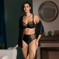 woman wearing a black lingerie set in a room with a blurred background