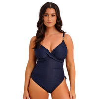 woman wearing a navy blue swimsuit on a white background