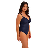 woman wearing a navy blue swimsuit on a white background