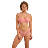 woman wearing a pink lace lingerie set on a white background