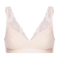 A pale blush-beige wireless bra with white floral lace trim along the scalloped V-neckline and underwire, shown against a plain white background.