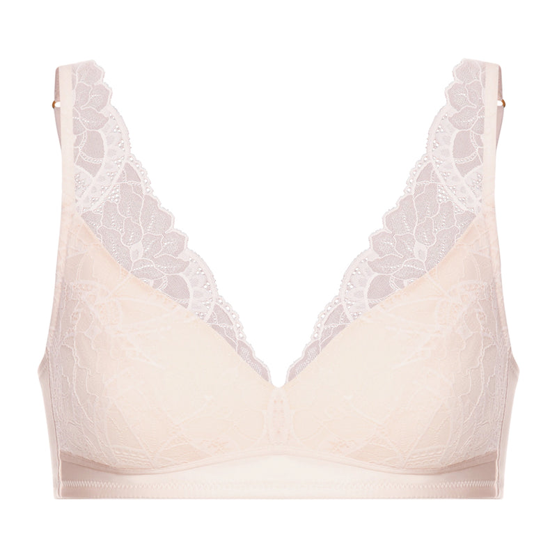 A pale blush-beige wireless bra with white floral lace trim along the scalloped V-neckline and underwire, shown against a plain white background.