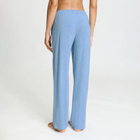 A person shown from the back wearing light blue heathered lounge pants against a plain light gray studio background.