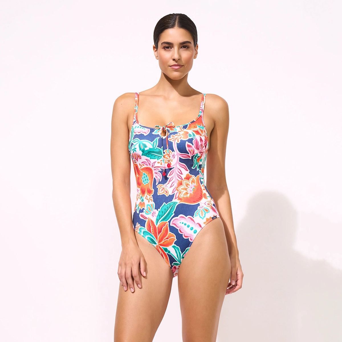 woman wearing a colourful floral swimsuit on a white background