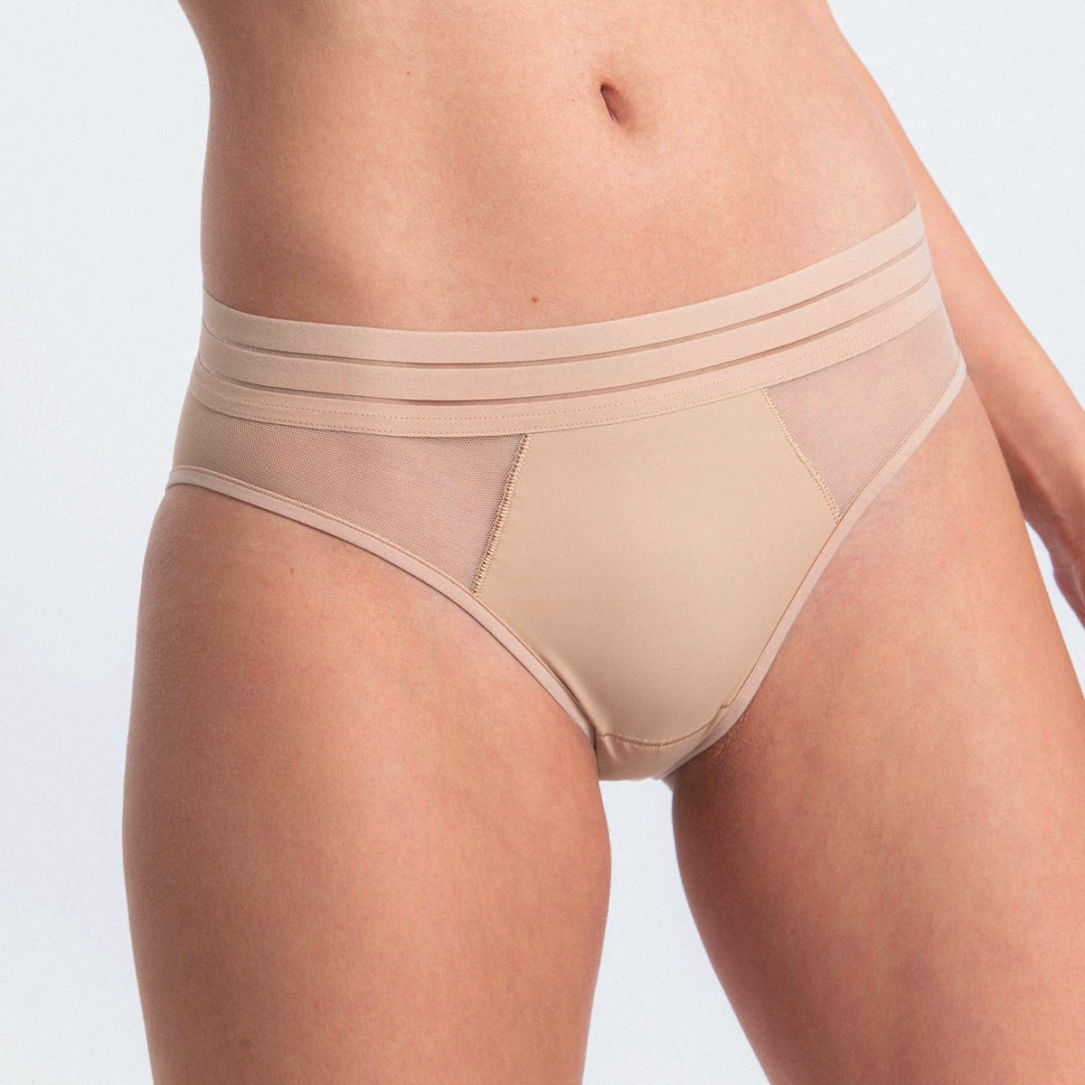beige underwear worn by a person on a light gray background