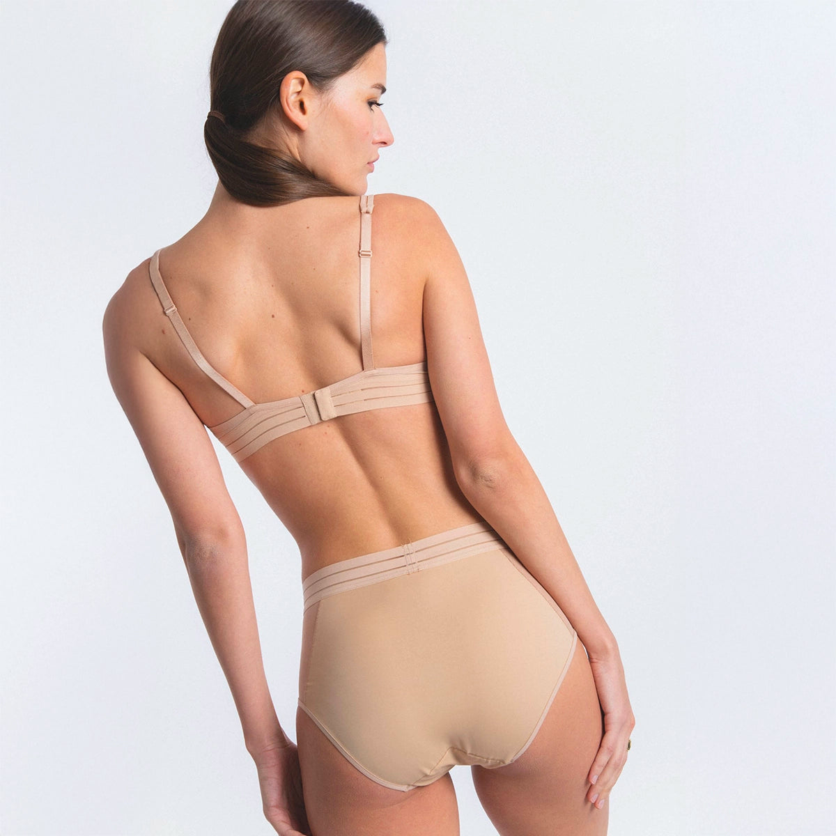 woman wearing beige lingerie on a white background