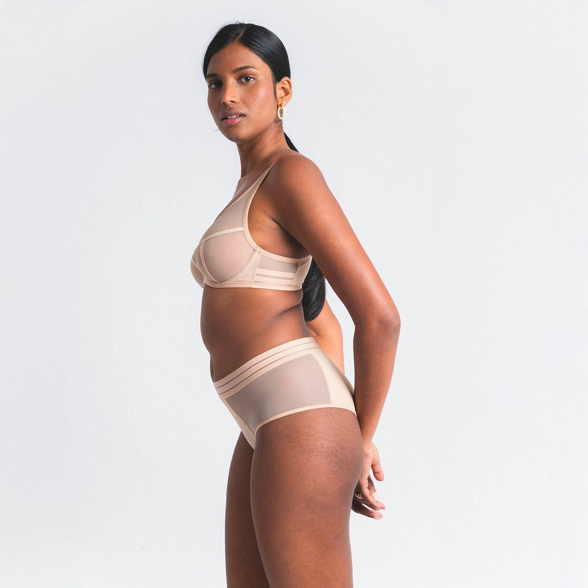 woman wearing beige lingerie on a plain background