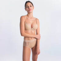 woman wearing a beige bra and underwear set on a white background