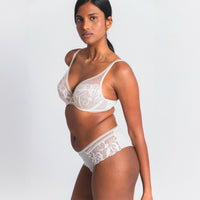 Woman wearing a Maison Lejaby Sin lace bra and panties set on a plain background