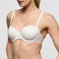 white bra with floral straps worn by a model on a plain background