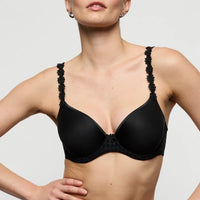 black bra with floral details on straps worn by a model against a plain background