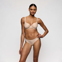 woman wearing a beige bra and panties set on a plain background