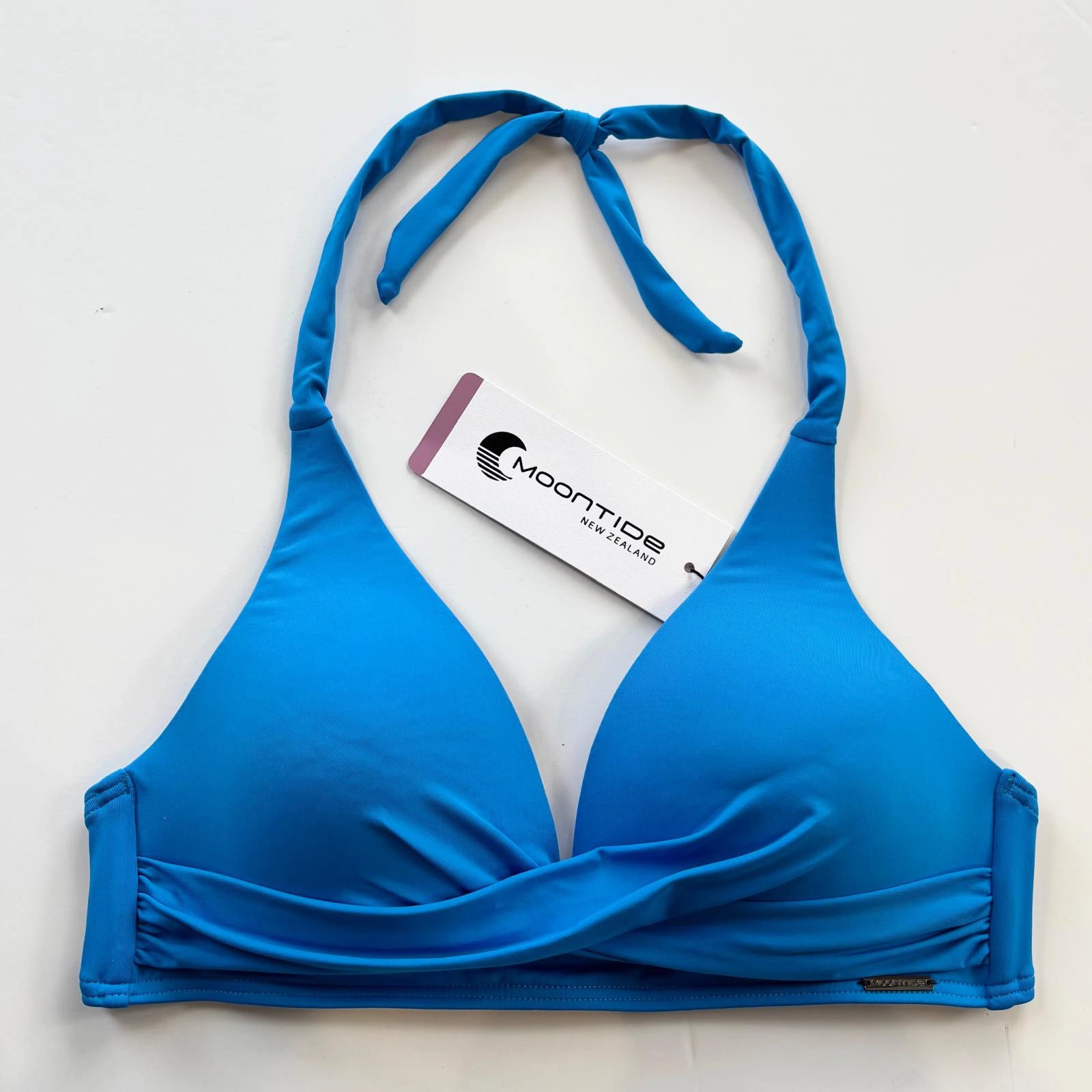 blue bikini top with a brand tag on a light background