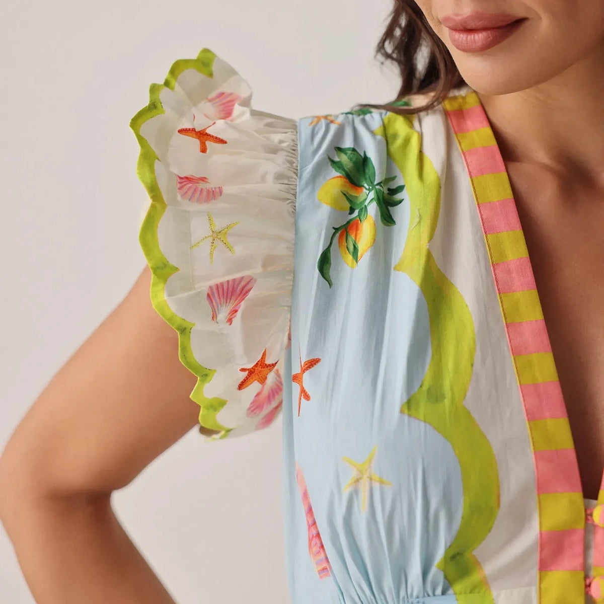 close-up of a colourful swimsuit with floral and shell patterns on a neutral background