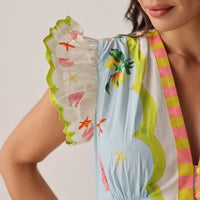 close-up of a colourful swimsuit with floral and shell patterns on a neutral background