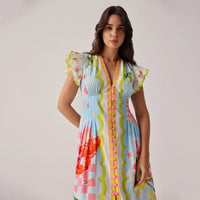 woman wearing a colourful patterned dress against a plain background