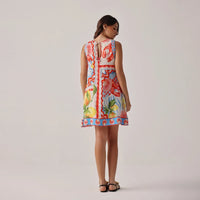 woman wearing a colourful floral dress with a plain background