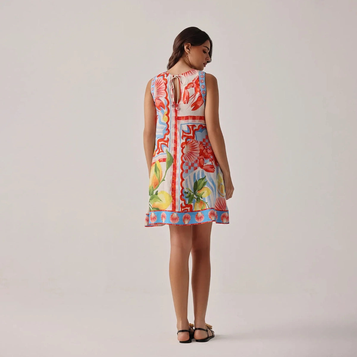 woman wearing a colourful floral dress with a plain background