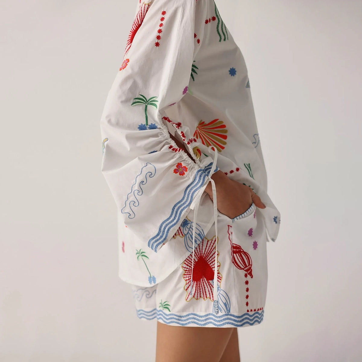 white outfit with colourful patterns on a plain background
