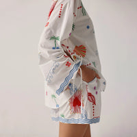 white outfit with colourful patterns on a plain background