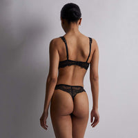 woman wearing black lace lingerie against a grey background