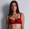 woman wearing a red lace bra against a plain background