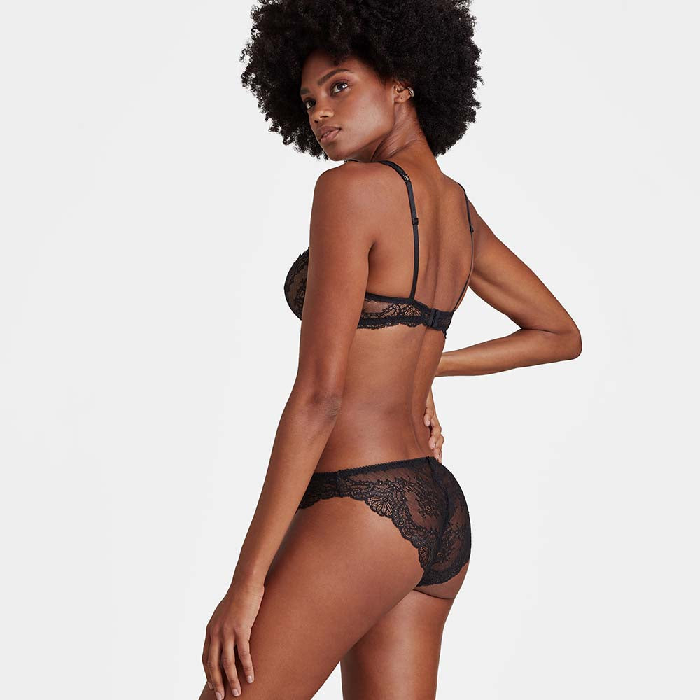 woman wearing black lace lingerie on a plain background