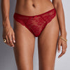 red lace underwear worn by a person on a grey background