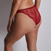 red lace underwear worn by a person on a neutral background
