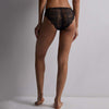 person wearing black lace underwear against a neutral background