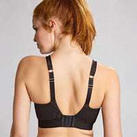 woman wearing a black bra against a plain background