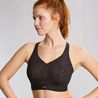 woman wearing a black sports bra against a grey background