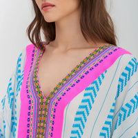 pitusa mini thobe in white with blue and pink detail close up on model